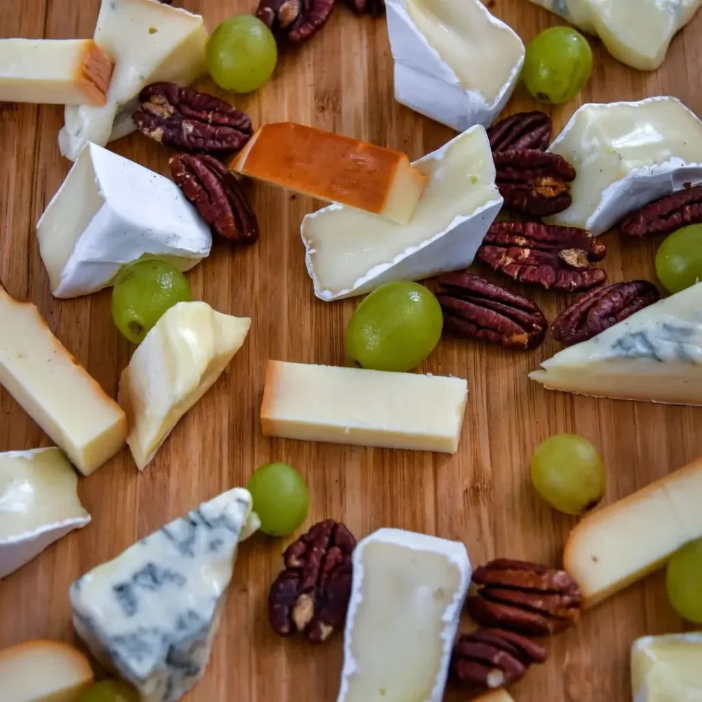 Fatias de queijo brie, parmesão em lascas e queijo azul em cubos