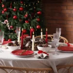Mesa de jantar de Natal decorada com louças brancas e vermelhas e velas
