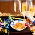 Mesa decorada para réveillon com taças de espumante e pequenos salgados coloridos